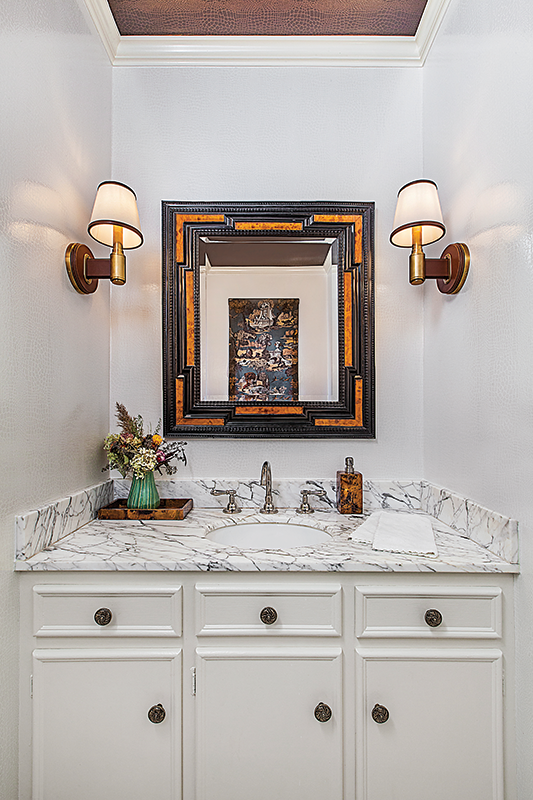 The powder room underwent an aesthetic upgrade, with new hardware, wallpaper, and lighting.