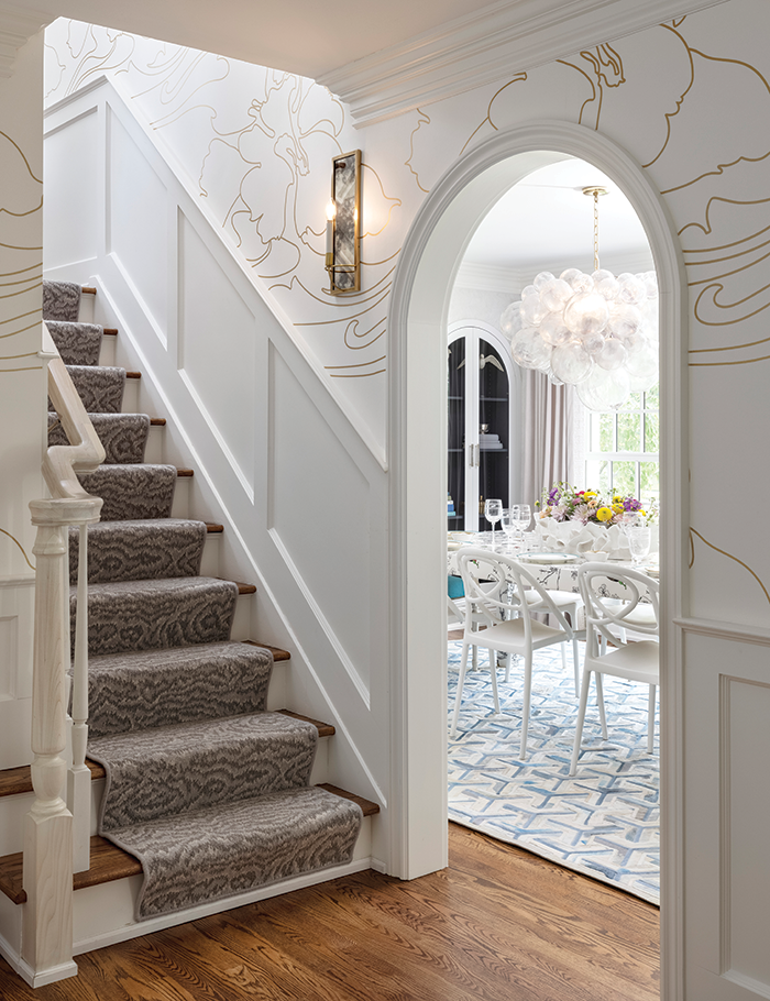“The staircase had a handrail with a newel on the right side and was partially in the dining room,” designer Dayna Rasschaert says. They changed the configuration and gave the staircase presence.