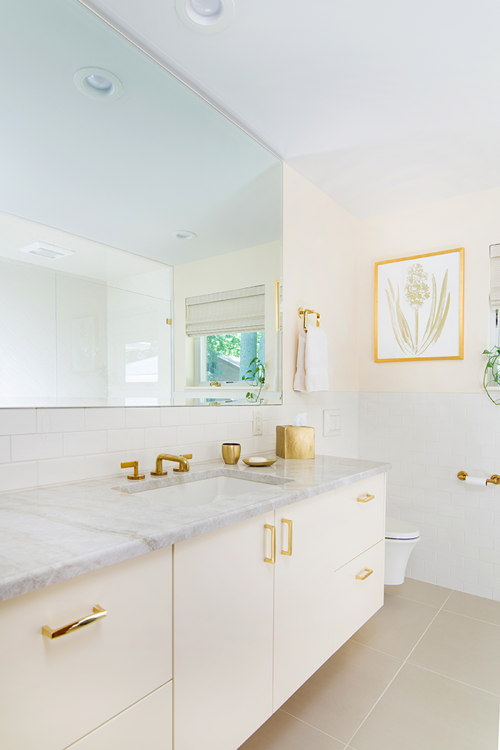 The homeowner’s choice of polished brass fixtures and hardware brightens a bathroom.